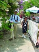 Two blind people taking a stroll using their long white canes.