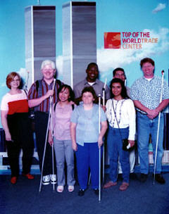 A group stand together in front of a photo of the World Trade Center.