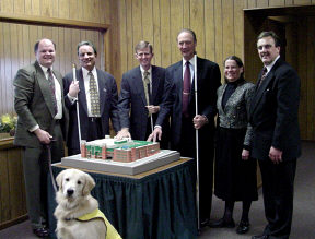 Six people posing around the model of the NRTIB.