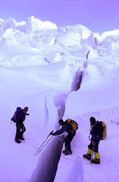 Erik Weihenmayer prepares to leap a crevasse by measuring the distance with his two climbing poles.
