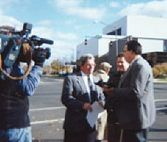 NFB of Pennsylvania President Jin Antonacci talks with Wilkes-Barre mayor Thomas McGroarty in front of a TV news camera