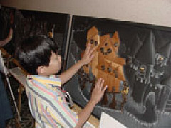 Andrew Wai of Pennsylvania examines tactile artwork on the wall of the exhibit hall.