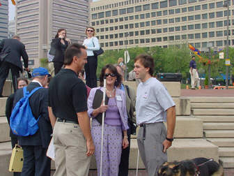 Gerry Sandusky, WBAL-TV Sports personality and master of ceremony for Meet-the-Blind-Month activities at the Inner Harbor; Betsy Zaborowski, NFB director of special  programs; and Erik Weihenmayer, the most recent member of the elite group of climbers to have summited the highest peaks on each of seven continents, enjoy a moment of relaxation in front of the bleachers before the Meet-the-Blind festivities.