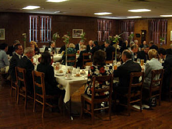 President Maurer and James Brinkley, president of Legg Mason, laugh together over lunch.   Other guests can be seen at the U-shaped tables.