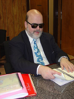 Robert Jaquiss reads a print/Braille book.