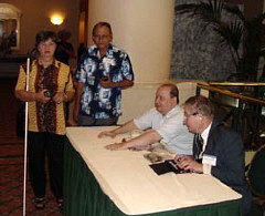 Ana Rodriguez(far left) and Curtis Willoughby (far right) at the FM receiver table with two unidentified men.