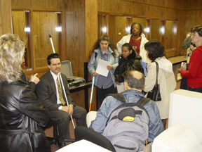 Participants had a chance to tour the NFB's International Braille and Techology Center for the Blind.  Maurice Peret (seated center left) speaks to the group.