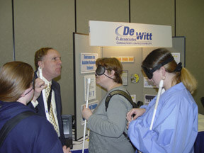 Participants had ample time to discuss technology products with vendors in the exhibit hall.  Richard Fox of Dewitt and Associates talks with three women in front of his display.