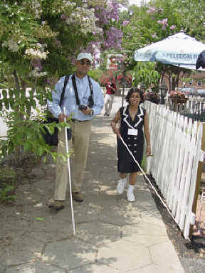 Sunish Gupta and Buna Dahal stride past an outdoor cafe during a GPS treasure hunt in Atlanta.