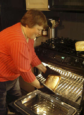 Terri Uttermohlen takes a loaf of bread out of the oven now that she has a stove she can control.