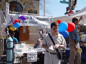 Greater Baltimore Chapter members meet and greet community residents at the Federal Hill Beat Festival in Baltimore, Maryland.   Here Ameenah Ghoston inflates balloons: Donna Ring types names in Braille on the Perkins Brailler; Chris Danielsen greets goers and hands out Braille alphabet cards and Steven Brand gives away free balloons.