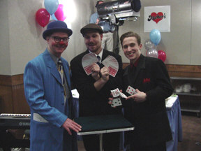 Magicians Ken Horsman; Chad Allen. an intern on the NFB staff; and Spencer Horsman pose with their card tricks.