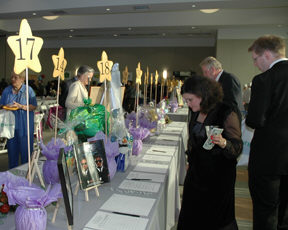 Celebration guests study item descriptins at the silent auction table.