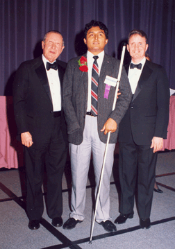 Carlos Serv&aacute;n won NFB scholarships in both 1992 and 1995. He is pictured here on the 1995 Banquet dais with Dr. Jernigan and President Maurer. Carlos has served as president of the NFB of Nebraska and a member of the NFB board of directors. He continues to be a Federation leader in Nebraska and across the nation. He earned both a law degree and an MBA and today serves as director of the adult training center at the Nebraska Commission for the Blind and Visually Impaired.