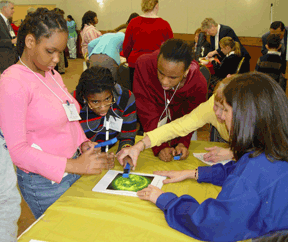 Kids sit around a table and examine the new book.
