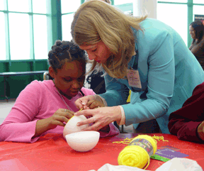 Mary Jo helps a young girl with her activity.