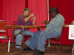 Jacob Webb and Abdul Abdullah are shown playing poker during the performance of the LCB play, Cajun Moon Rising.