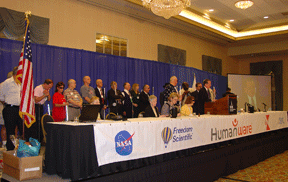 United States military veterans stand together on stage. President Maurer is at the podium.