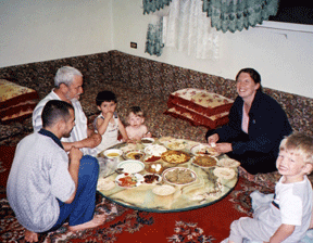 A Jordanian family invited the Jakemans to share their meal even though they were virtual strangers. Here they are seated on the floor around a low table spread with food. Aliya, Rebekah, and Calan can be seen at the right of the picture. Their hosts are to the left, and Dave Jakeman was the photographer.