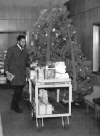 Man gathering gifts and placing them on a cart.