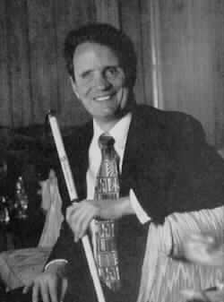Photo of Marc Maurer seated, holding his white cane.