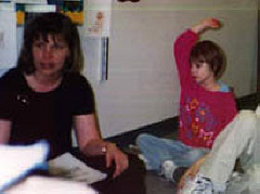 I know the answer!  Rachel raises her hand while her homeroom teacher, Mrs. Birkholz, leads the class in a discussion.