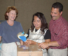 UPS employee volunteers Terri Foss, Bobbi Shunnarah, and Greg Worthington cheerfully and efficiently box up Braille books for shipment at the first annual Braille book flea market event.   They, and several other UPS volunteers, packed and mailed eighty boxes to addresses all over the country.   Months in advance of the convention, the volunteers collected and stored sixty-five boxes of Braille books, then transported them to the hotel for the event.   The flea market generated over $1,000 in donations which will be used for the 2004 Braille book flea market at the NFB convention in Atlanta.