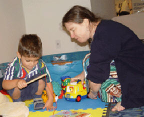 Heather Field in a typical pose: on the floot playing with Discovery Toys and a toddler.