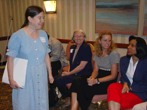 Heather stands and addresses her seated class.