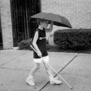 A young Jon Gabry learns to multi-task as he carries his umbrella and uses his cane in the rain.