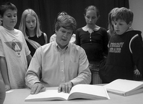 Kirk Adams reads a book in Braille to a group of elementary students who are participating in the Braille Is Beautiful program.
