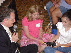 NFB President Maurer seated on the floor with two girls