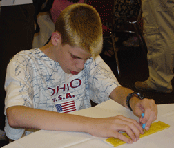 Kyle Conley displays the mechanics of using a slate and stylus.