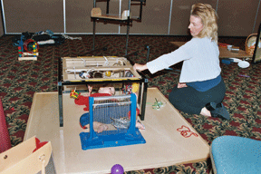 The Little Room in action. A child lies on the resonance board surrounded by stimuli, as a caregiver looks on without interfering.