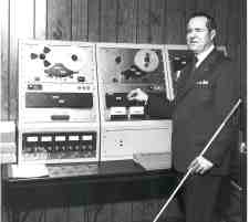 Kenneth Jernigan stands next to a high-speed tape duplicator.