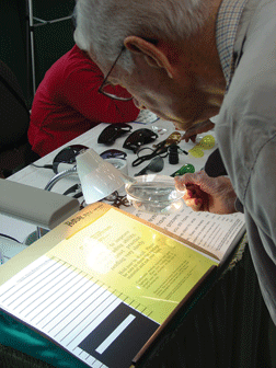 A man uses a magnifier to read a notice.