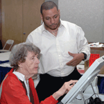 Senior woman learns how to vote at an accessible voting machine.