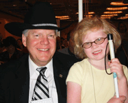 A blind man and child smile for the camera.