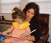 A mother reads with her young daughter