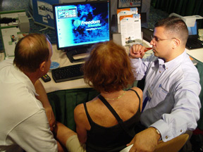Jerry Marindin, regional accounts manager, Blind/Low Vision Group, (right) demonstrates Freedom Scientific equipment to two people.