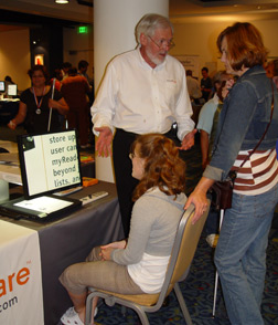 Jim Halliday, vice president for advocacy, demonstrates low-vision equipment to a mother and daughter.