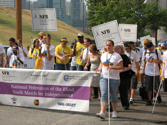 Marchers followed the Youth Slam banner, seen here in the foreground, as they marched from the Inner Harbor to the National Center for the Blind. Designated students proudly carried their state placards as they marched.