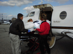 The paramedics slide the gurney into the air ambulance.