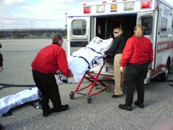 Three paramedics lift Betsy�s gurney out of the ambulance.