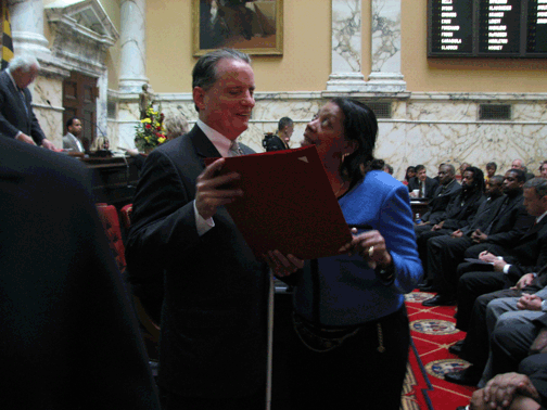 Maryland Senator Joan Carter Conway (right) presents a plaque to NFB President Marc Maurer in Maryland’s senate chamber.