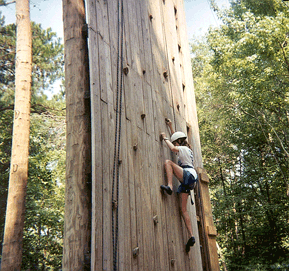 A STEP student scales a climbing wall.