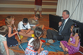 Marc Maurer sits on the floor in order to talk to the kids at their level.
