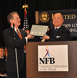 Director of the Mint Ed Moy presents a Braille and print plaque to President Maurer during his remarks at the celebration.