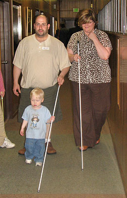 Amy Phelps, director of rehabilitation at Blind Industries and Services of Maryland, and Marc Fass, a parent attending the conference on a cane walk with Marc's son Andy.