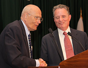 Congressman John Dingell shakes hands with President Maurer on the platform.